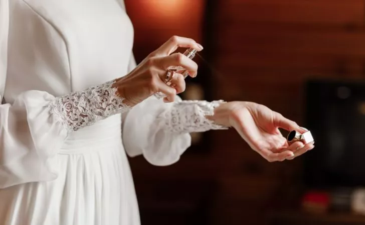 A person spraying perfume on their wrist