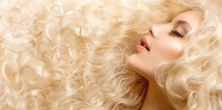 A woman with long wavy healthy blonde hair