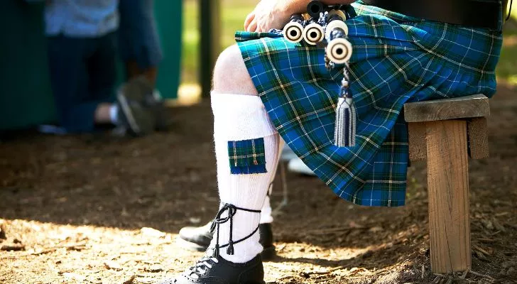 A person wearing a blue and green kilt.