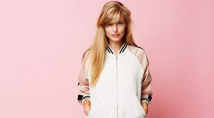A woman wearing a pink and white varsity jacket