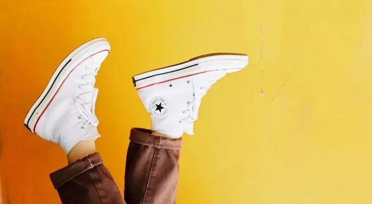 A person wearing white Chuck Taylors